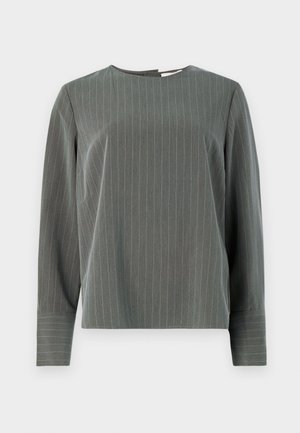 Szürke csíkos, hosszú ujjú felső, kerek nyakú, lazább fazonban. A világos színű függőleges csíkok kontrasztot képviselnek a sötétebb szövet textúrájával.