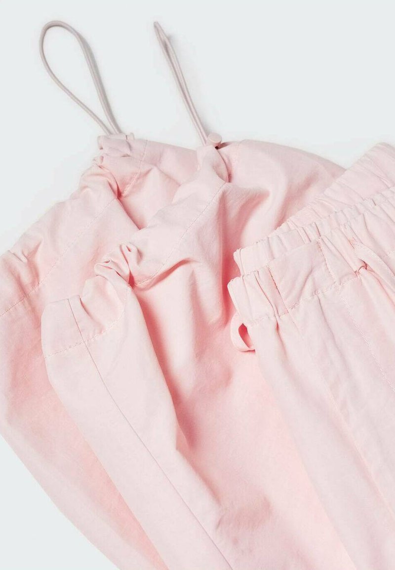 Pantalones de tiro en color rosa claro, hechos de una tela suave; cuentan con una cintura fruncida y puños elásticos para un ajuste cómodo.