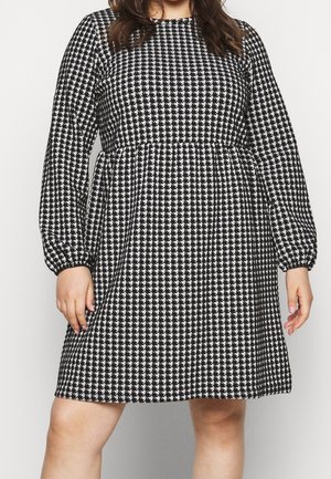 Zwart-witte houndstooth-gepatroniseerde jurk met lange pofmouwen en een getailleerde taille, gemaakt van een textuurstof.