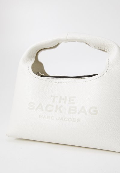 Sac à main en cuir blanc avec une finition texturée, doté d'une poignée arrondie et d'un logo en relief. Fermeture à glissière sur le dessus.