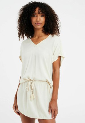 Abito corto beige chiaro con scollo a V, maniche corte, vita regolabile con cordoncino e frange, tessuto morbido e vestibilità rilassata.