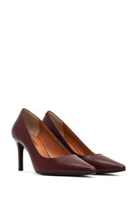 Bordeaux leren hoge hakken met een spitse neus, slanke stiletto hak en een gladde textuur. Het interieur heeft een tan kleurige binnenzool.