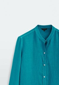 Teal knäppt skjorta med mandarin-krage, långa ärmar, mjuk textur och subtil lyster. Har vita plastknappar fram.