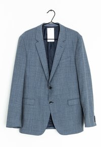 Blazer grigio a quadri appeso, con revers a punta, due tasche frontali e chiusura a un bottone, con una fodera interna liscia.