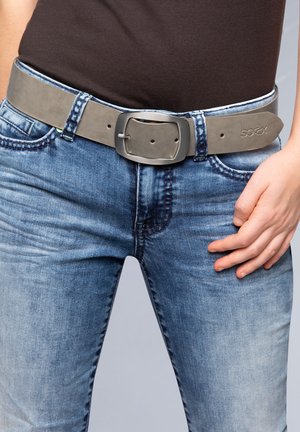 Grey leather belt with a matte finish, rectangular metal buckle, worn over blue denim jeans. Notable stitching details on the jeans.