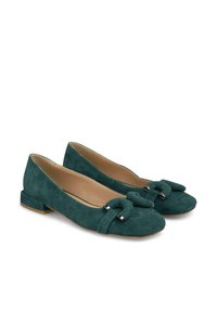 Ballerines en suede vert avec un détail nœud, des accents argentés et un petit talon empilable. Texture lisse et forme de bout arrondi.