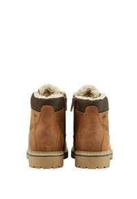 Paire de bottines en cuir marron avec doublure en fourrure beige, semelles épaisses en caoutchouc et fermetures éclair latérales, vues de dos.