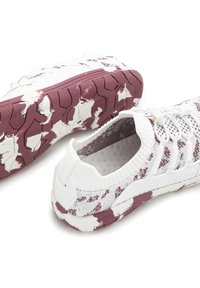 Sportliche Schuhe mit einem weißen Mesh-Obermaterial, das ein dunkelrotes und weißes Camouflage-Muster aufweist. Texturierte Gummisohle mit einem Grip-Design und Akzenten an der Ferse.