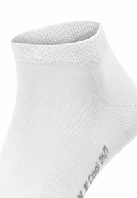 Vit ankelsocka gjord av ett slätt, elastiskt tyg med ribbat mönster upptill och subtil tryck på sidan.