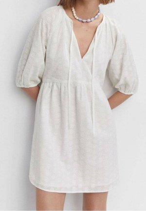 Biała sukienka z bufiastymi rękawami, dekoltem w kształcie litery V i regulowanym paskiem w talii. Charakteryzuje się delikatnym kwiatowym wzorem oraz lekkim, teksturowanym materiałem.