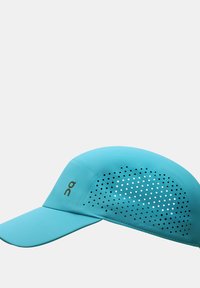 Turquoise cap met geperforeerd paneel voor ademend vermogen. Voorzien van een gebogen visor en logo. Glad oppervlak met een lichtgewicht ontwerp.