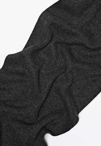 Tissu tricoté côtelé gris foncé avec une texture douce, drapé pour montrer sa fluidité et ses subtiles variations de teinte. Aucun motif ni matériel visible.