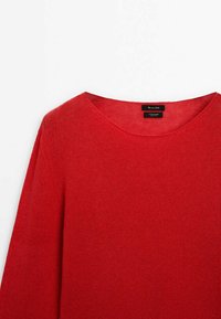Pull en tricot rouge avec un col rond et des manches longues. Fabriqué dans un tissu doux, présentant une texture lisse et un design minimaliste.