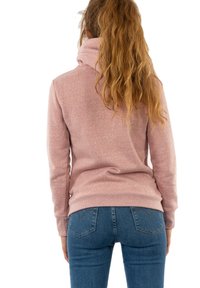 Sudadera con capucha en mezcla de algodón de color rosa polvo, con puños y dobladillo acanalados, combinada con vaqueros de mezclilla azul. Superficie texturizada con sutiles motas.