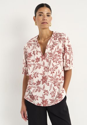 Blus med blommönster i ljus grädde med maroon blommor. Har V-urringning, korta ärmar och avslappnad passform. Texturerad tygdetalj.