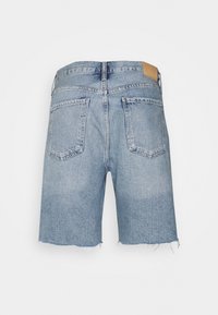 Ljusblå denimshorts med fransat fåll och två bakfickor. Midjan har en läderetikett i tan.