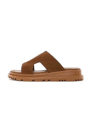 Sandalias de ante marrón tipo slide con punta abierta, diseño de cortes y suela de goma con un patrón de agarre texturizado.