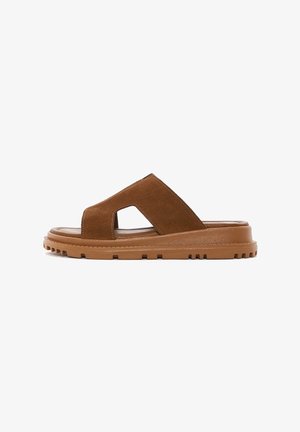 Sandalias de ante marrón tipo slide con punta abierta, diseño de cortes y suela de goma con un patrón de agarre texturizado.