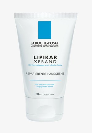 Weiße Tube mit einem blauen Quadratlogo und schwarzem Text. Enthält 50 ml Handcreme, die auf die Reparatur von sehr trockenen Händen abzielt.