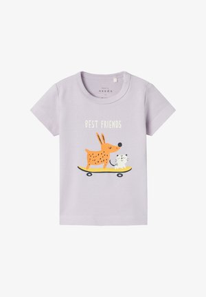 Camiseta lavanda para niño pequeño con texto "Mejores Amigos" e ilustración de un perro naranja y un gato blanco montando un patinete amarillo.