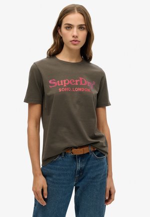 Olijfgroene katoenen t-shirt met een ronde hals en korte mouwen, met roze tekst "SuperDry SOHO LONDON" in een vet lettertype.
