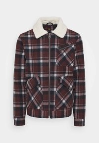 Giacca a quadri rossa e blu scuro con colletto in pelliccia sintetica bianca. Presenta chiusura con cerniera, taschino sul petto e due tasche anteriori. Materiale morbido in misto lana.