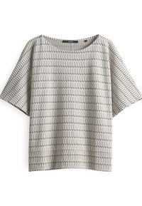 Lightweight beige top with a textured pattern of thin black zigzags, round neckline, and short sleeves. Relaxed fit and soft fabric.