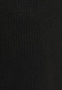 Svart stickad tyg med ribbad textur, med ett konsekvent mönster och tungt material, lämpligt för plagg eller tillbehör.