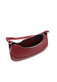 Rote Ledertasche mit einer geschwungenen Form, ausgestattet mit einem Reißverschluss und einem verstellbaren Tragegurt. Das Innere verfügt über Taschen zur Organisation.