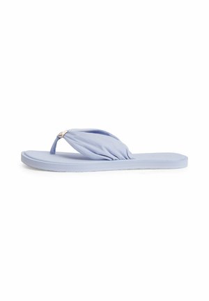 Chancla plana azul claro con tira tipo tanga de tela acolchada y pequeño detalle metálico de logo sobre fondo blanco.
