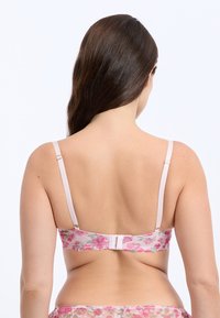 Bralette en dentelle de couleur rose avec un motif floral, doté de bretelles réglables et d'une fermeture à crochet. Texture douce et bords festonnés au niveau de la bande.