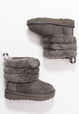 Par de botas de invierno de ante gris con puños gruesos de forro polar plegados y suelas de goma, mostradas en vistas superior y lateral sobre fondo blanco.