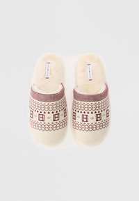 Papuci tricotati cu o bază crem și modele geometrice burgundy. Foderare moale și pufoasă; design ușor de încălțat; etichetă de marcă pe partea superioară.