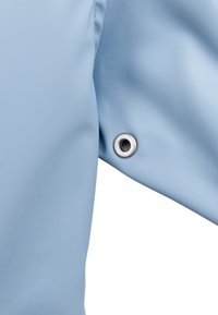 Jasnoniebieski rękaw kurtki z gładką fakturą i srebrnym oczkiem blisko mankietu dla dodatkowej funkcjonalności.