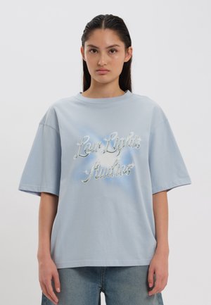 Hele sinise puuvillane T-särk lühikeste varrukatega, millel on tikitud tekst läikivas hõbedases viimistluses. Mugav lõige ja ümar kaelusekael.