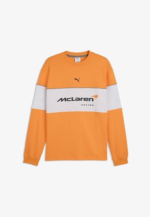 Oranje shirt met lange mouwen en een grijze horizontale streep, Puma-logo bovenaan en "McLaren Racing"-tekst met logo in het midden van de borst.