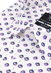 Mężczyzna w dopasowanej koszuli z białej tkaniny z geometrycznym wzorem małych kwadratów w odcieniach niebieskiego, fioletowego i czarnego. Posiada kołnierzyk zapinany na guziki oraz metki.