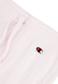 Rosa Baumwollshorts mit elastischem Bund, verstellbarem Kordelzug und kleinem gesticktem Logo in Rot und Schwarz auf der Vorderseite.