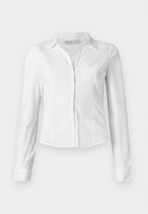 Pikad varrukad, valge nööbitav särk krae ja slim fit lõikega, ees kuue nööbiga, ühtlasel taustal.