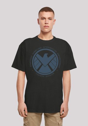 Svart bomull t-skjorte med et sirkulært blått grafikk med et ørneemblem og tekst "Strategic Homeland Intervention Enforcement Logistics Division."
