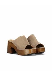 Beige suède open-toe mules met een brede band, voorzien van een chunky houten hak en platform. Glad textuur met een minimalistisch ontwerp.