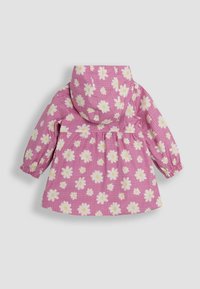 Růžový pláštěnka s mřížkovaným vzorem a bílými sedmikráskami. Obsahuje kapuci, elastické manžety a rozšířený střih pro usnadnění pohybu.