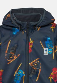 Ninja-motivierte Kapuzenjacke in Marineblau mit bunten Charakterdrucken; verfügt über einen Reißverschluss und ein weiches Innenfutter.