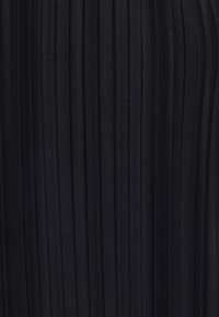 Svart tyg med smala vertikala veck som skapar ett texturerat, linjärt mönster.