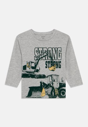 Szürke hosszú ujjú póló, amelyen építőipari járművek illusztrációi és kétszer is vastag zöld betűkkel nyomtatva a "STRONG" szó szerepel.