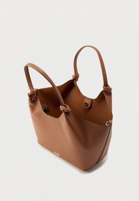 Καφέ τσάντα ώμου από δέρμα με δύο ιμάντες, μαγνητικό κλείσιμο και λεία υφή. Διαθέτει διακριτικό λογότυπο στο μπροστινό μέρος.