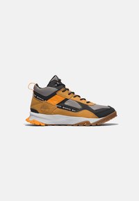 Halbhoher Wanderschuh mit einer Mischung aus grauen, schwarzen und orangen Materialien, Netzpaneelen und einer robusten Gummisohle mit strukturierter Oberfläche.