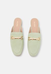 Mules en daim vert à enfiler avec un bout arrondi, accent en métal doré, et une semelle intérieure lisse couleur rose pâle arborant le logo ALDO.