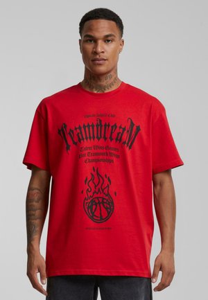 Rød kortærmet t-shirt med sort tekst og grafik, herunder flammer og et basketballdesign, lavet af bomuldsstof.