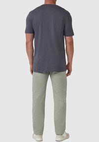 Grijze t-shirt met korte mouwen, gemaakt van lichtgewicht katoen; gecombineerd met lichtgroene broek, van katoenmix, rechte snit, en crèmekleurige sneakers.